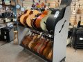 grey shelves holding mariachi instruments, placed in the middle of a musical instrument store