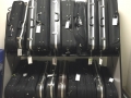 a two tiered shelf holding black violin cases