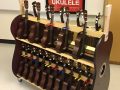 a cart filled with ukuleles, in front of a red poster
