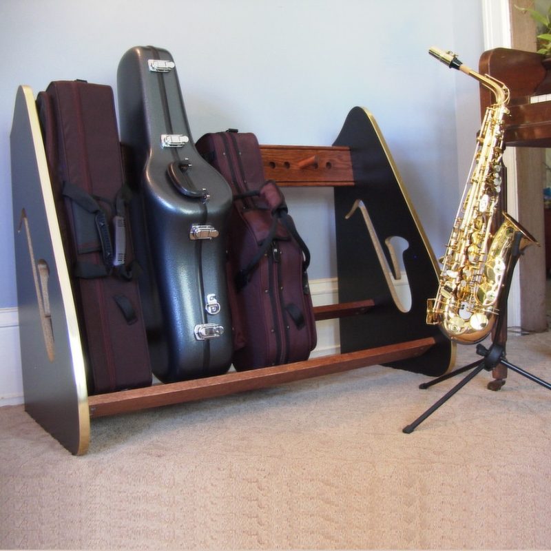 Sax cases in a wooden rack, next a saxophone in a single stand